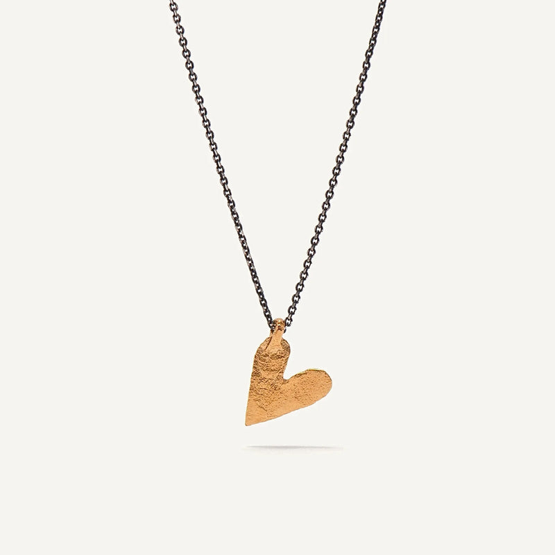 Gold heart-shaped pendant on a black chain against a white background