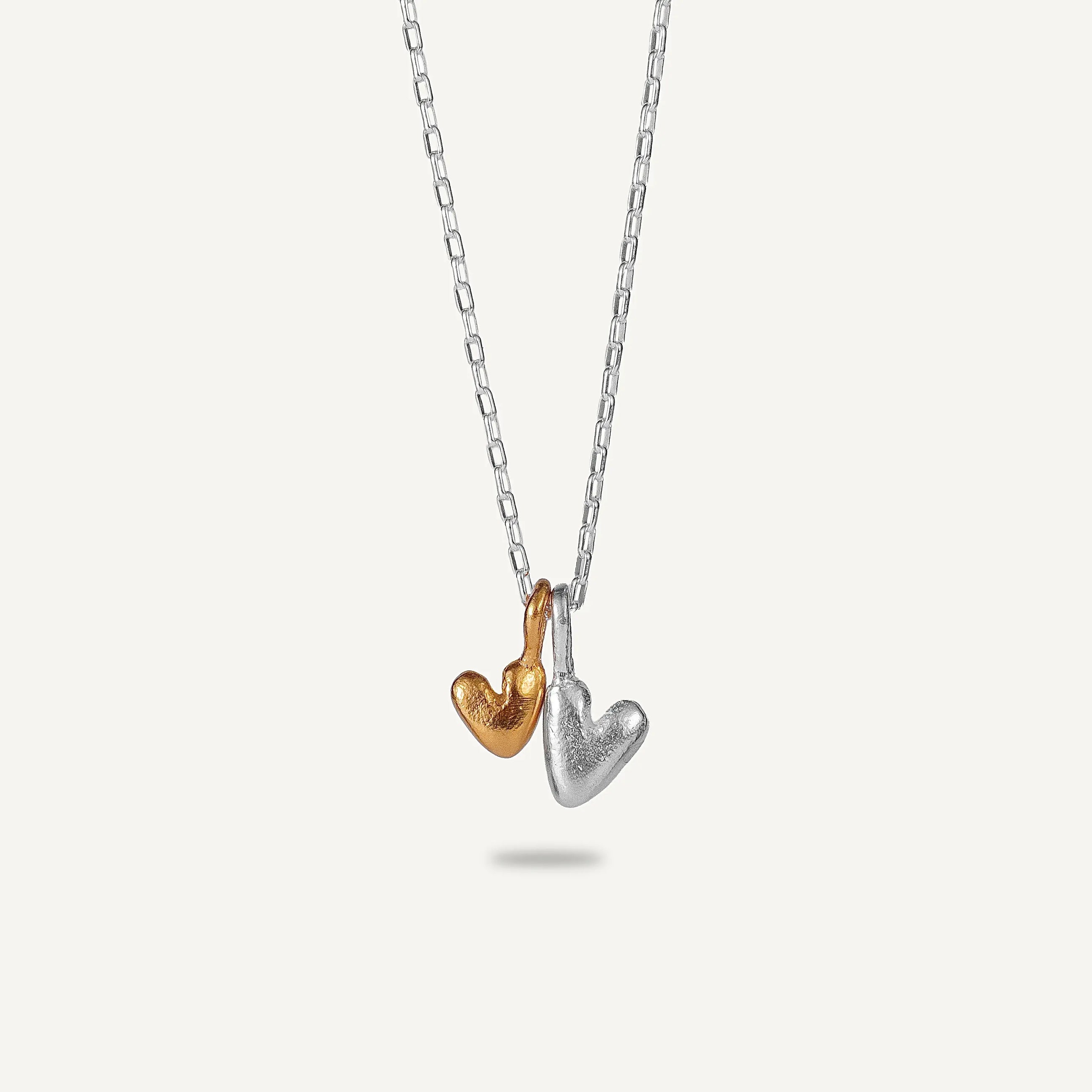 A gold plated silver necklace with a heart-shaped pendant.