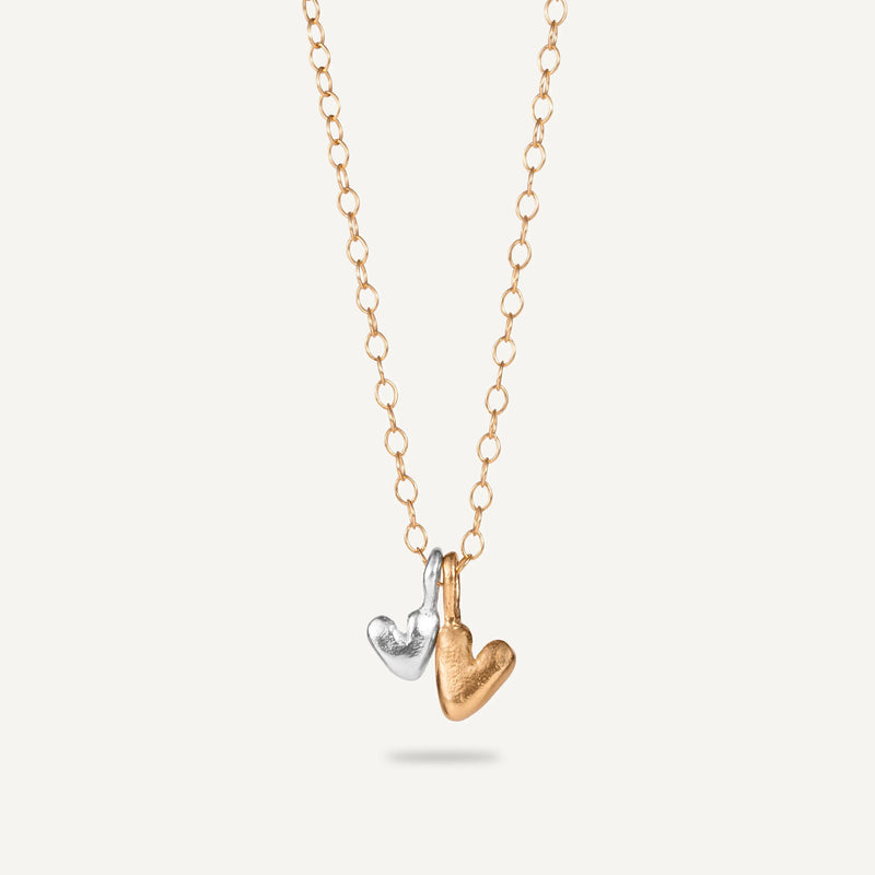 A gold plated silver necklace with a heart-shaped pendant.