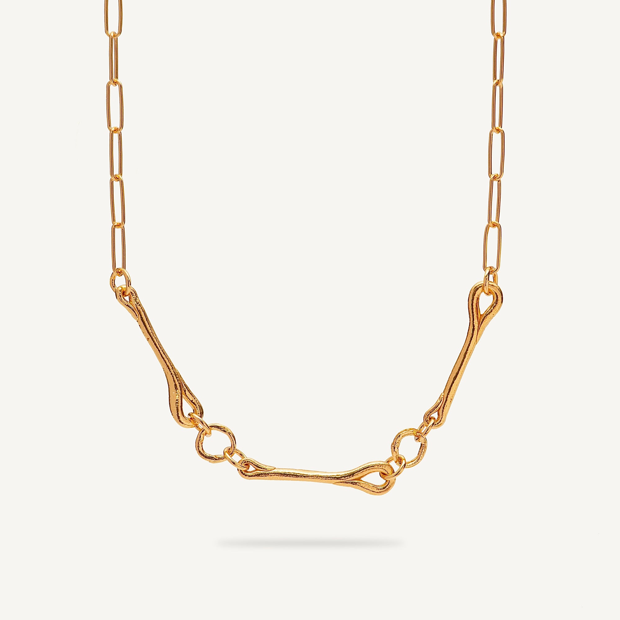 Gold necklace on a light beige background