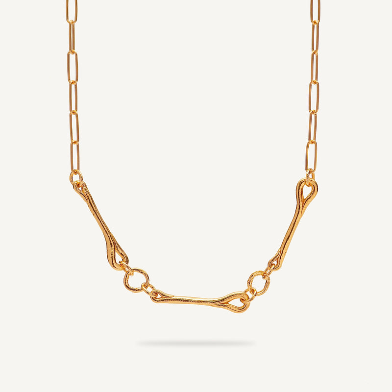 Gold necklace on a light beige background