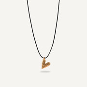 A gold plated silver necklace with a heart-shaped pendant on a black string.