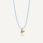 A gold plated silver necklace with a heart-shaped pendant on a blue string.