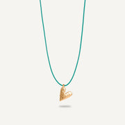 A gold plated silver necklace with a heart-shaped pendant on a green string.