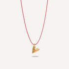 A gold plated silver necklace with a heart-shaped pendant on a red string.