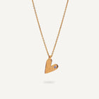 Gold heart-shaped pendant necklace on a light gray background