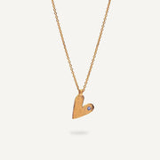 Gold heart-shaped pendant necklace on a light gray background