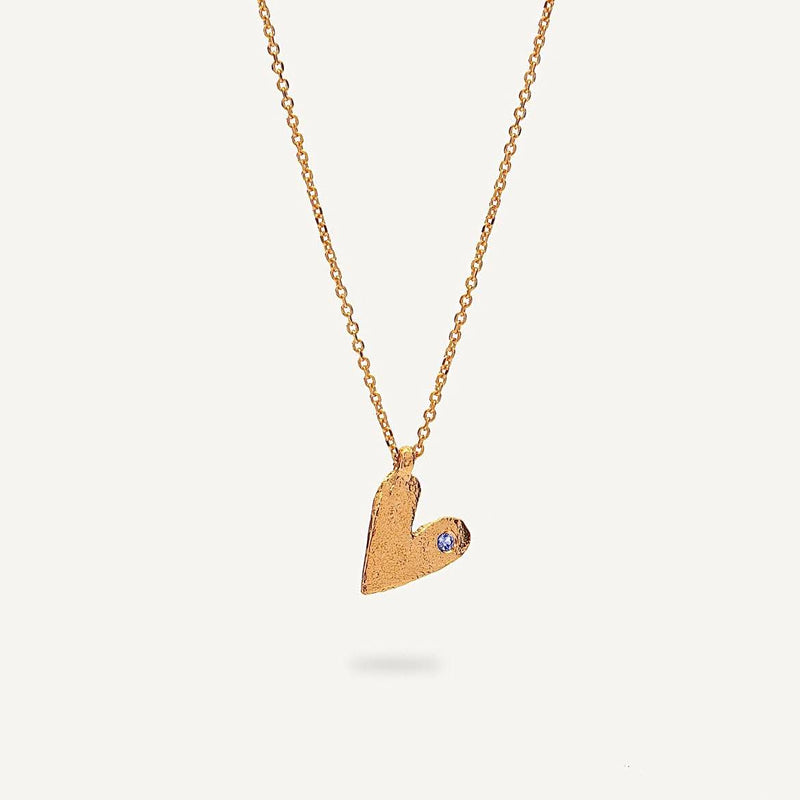 Gold heart-shaped pendant necklace on a light gray background