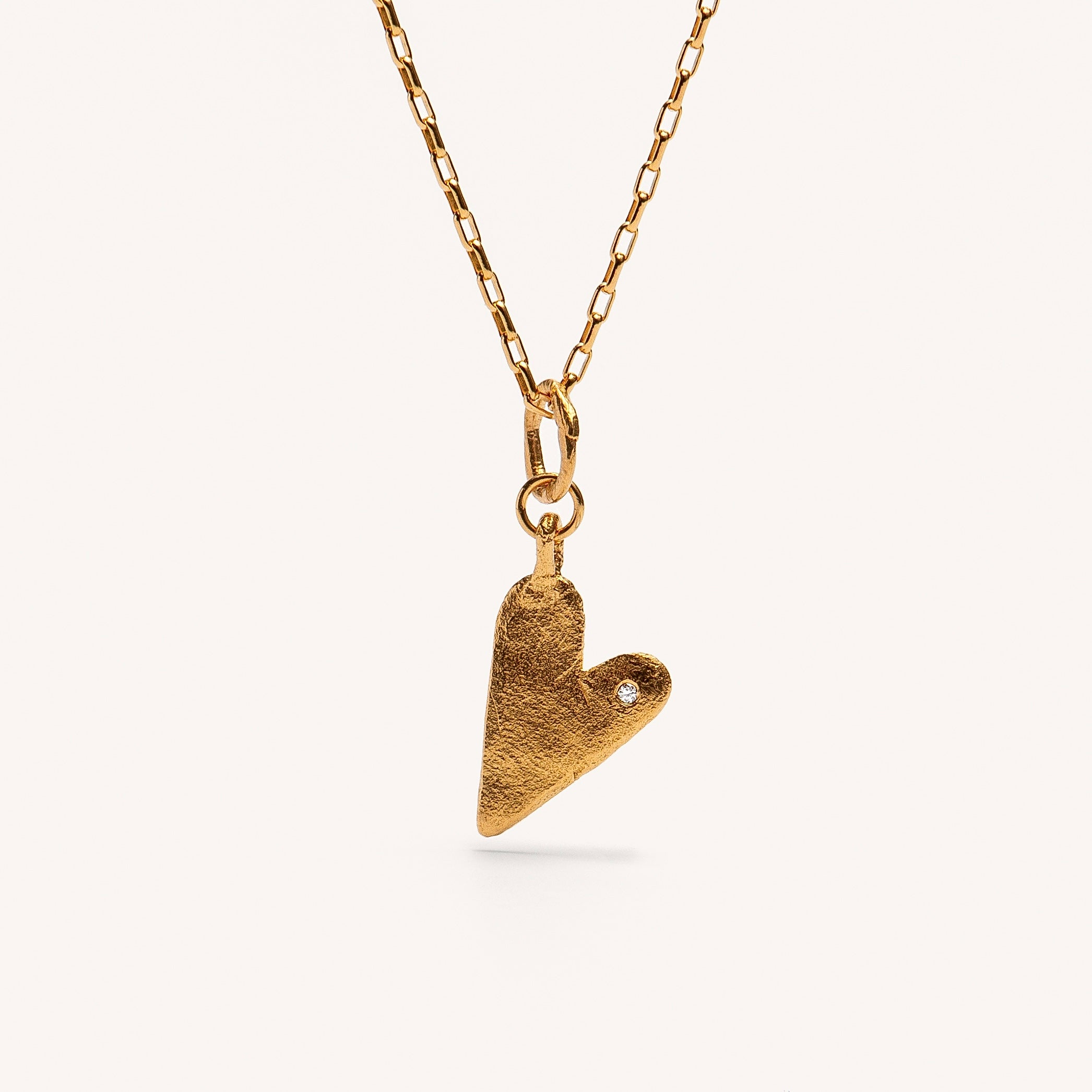 A gold plated silver necklace with a heart-shaped pendant featuring a white diamond.