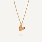 Gold heart-shaped pendant necklace on a light gray background