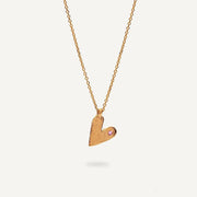 Gold heart-shaped pendant necklace on a light gray background