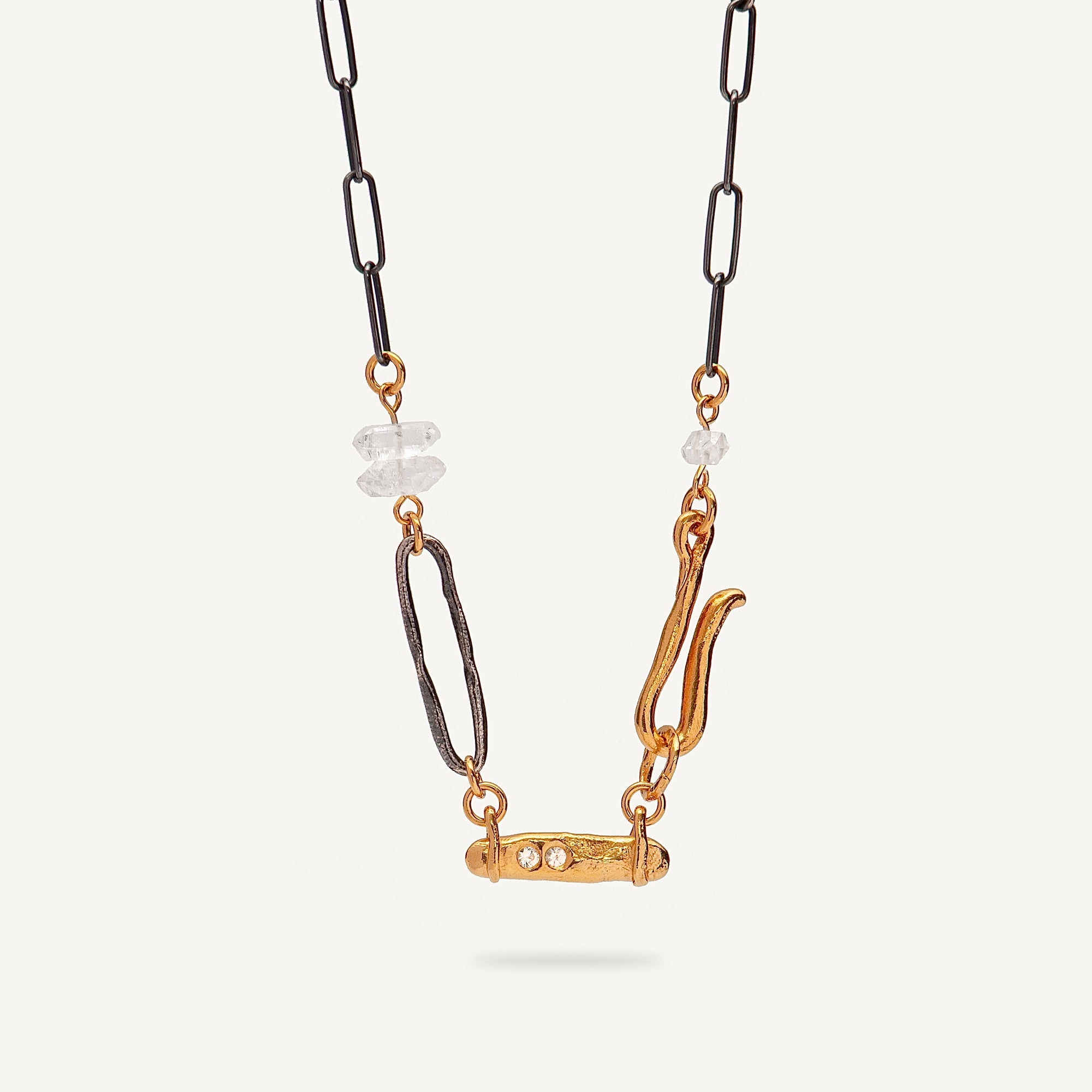 Necklace with gold and black chain and decorative elements on a white background