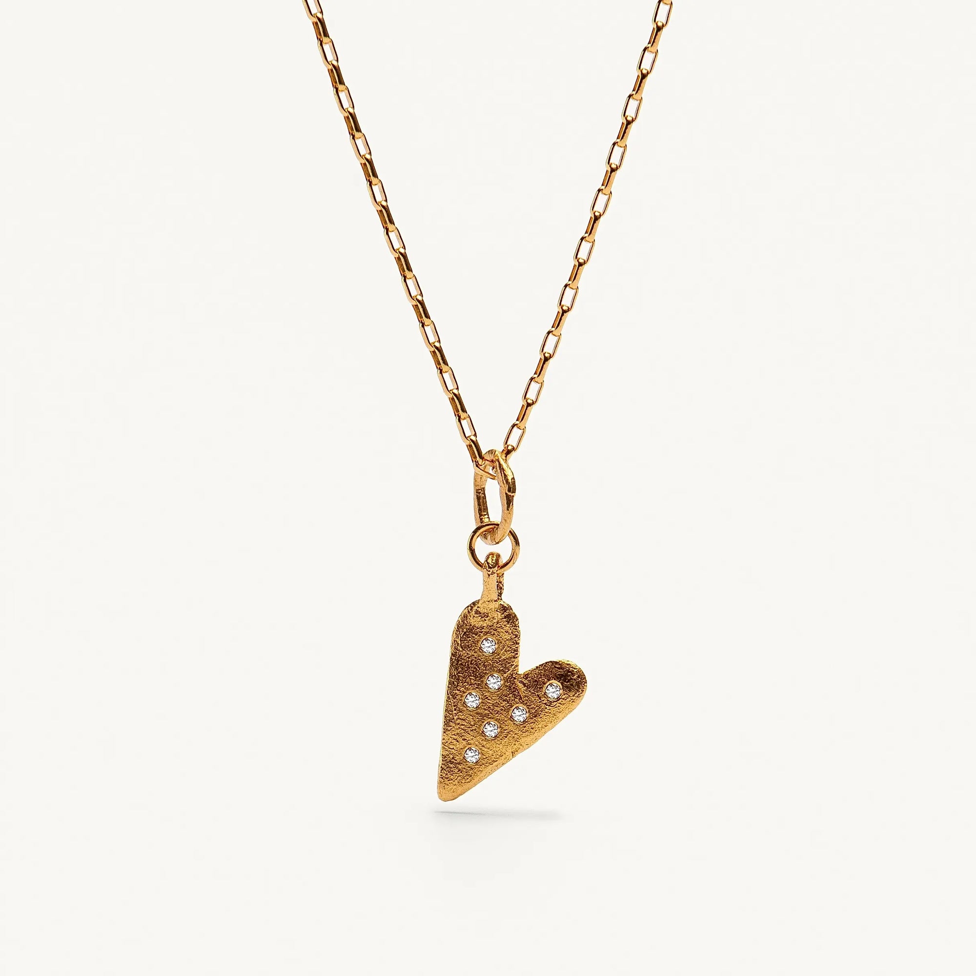 A gold plated silver necklace featuring a heart-shaped pendant with sapphires.