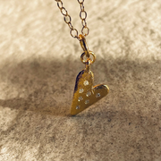 A gold plated silver necklace featuring a heart-shaped pendant with sapphires.