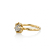 Gold-plated ring with a raw white diamond on a white background