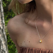Close-up of a person wearing a gold-plated silver necklace with Akoya pearl
