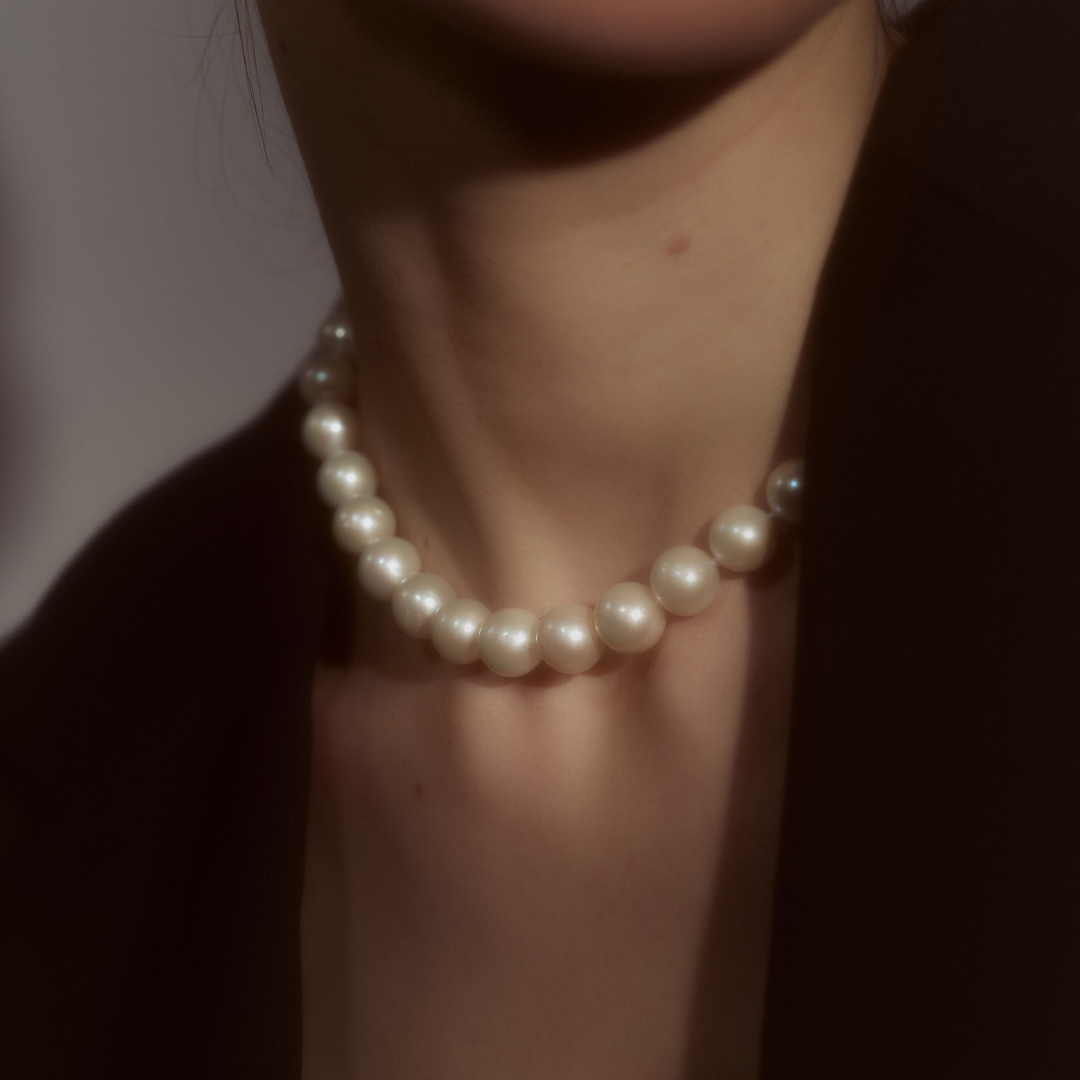 Woman wearing a necklace composed of round freshwater pearls and fine sterling silver.