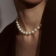 Woman wearing a necklace composed of round freshwater pearls and fine sterling silver.