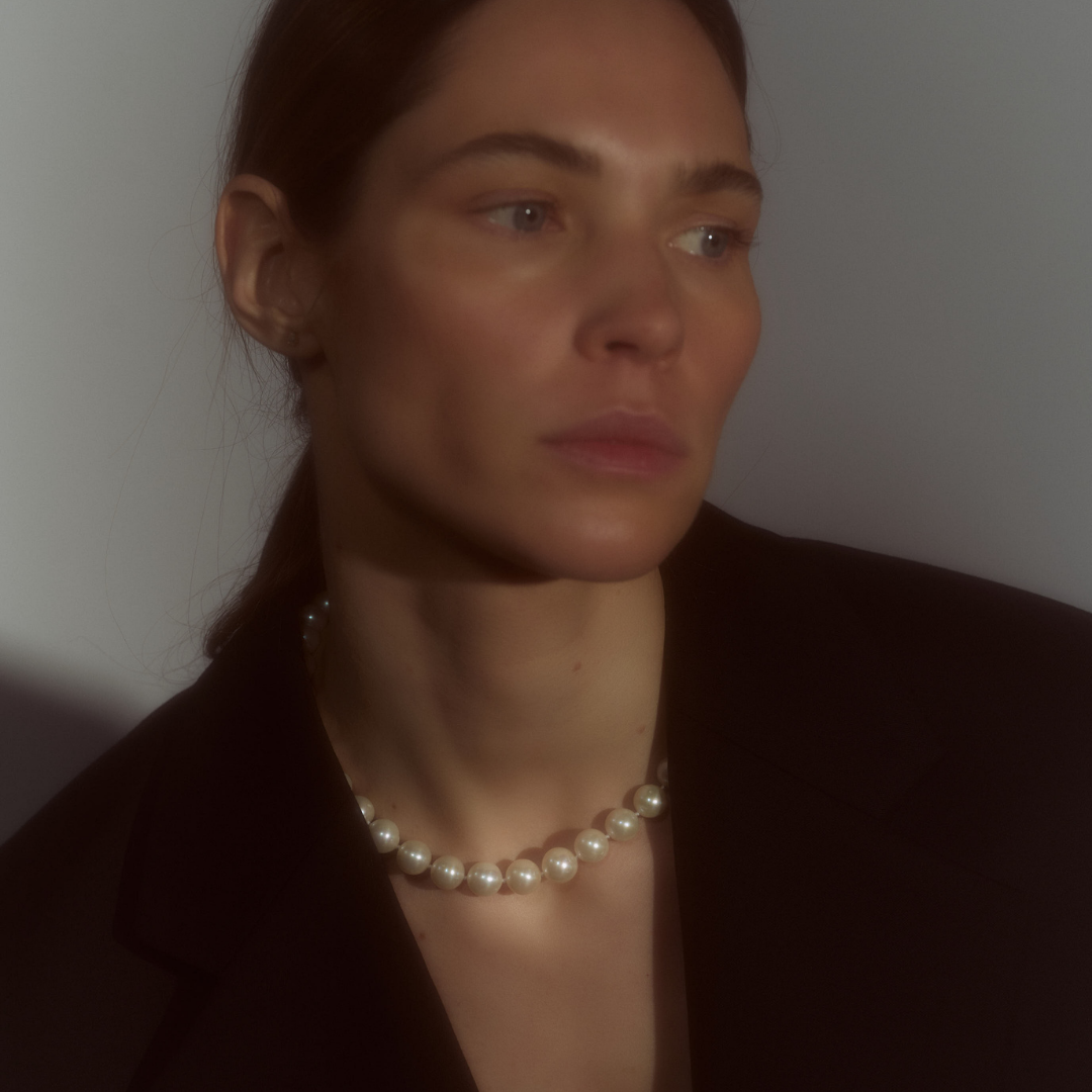 Woman wearing a necklace composed of round freshwater pearls and fine sterling silver.