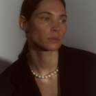 Woman wearing a necklace composed of round freshwater pearls and fine sterling silver.