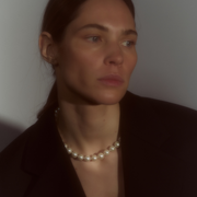 Woman wearing a necklace composed of round freshwater pearls and fine sterling silver.