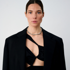 Woman wearing a statement necklace crafted from fine sterling silver beads in varying sizes. 