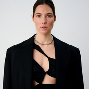 Woman wearing a statement necklace crafted from fine sterling silver beads in varying sizes. 