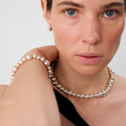 Woman wearing a statement necklace crafted from fine sterling silver beads in varying sizes. 