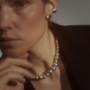 Woman wearing a statement necklace crafted from fine sterling silver beads in varying sizes. 