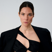 Woman wearing a delicate freshwater pearl necklace featuring organically shaped pearls and a minimalist silver clasp.