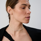 Woman wearing a delicate freshwater pearl necklace featuring organically shaped pearls and a minimalist silver clasp.