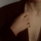 Woman wearing a minimalist polished silver ring with a smooth, rounded silhouette.