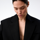 Woman wearing a white gold pendant featuring a round brilliant-cut diamond, suspended from a delicate gold chain. 