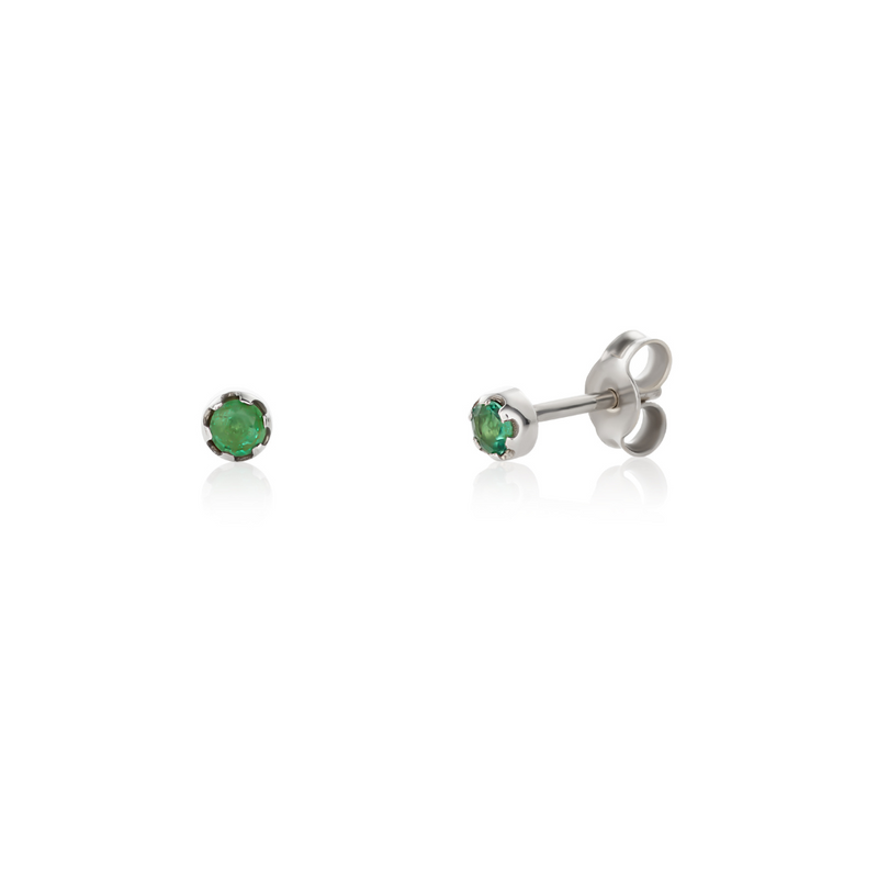 A pair of 14k white gold stud earrings with emeralds set in them, displayed against a white background.