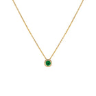 Yellow gold necklace with emerald pendant on a white background