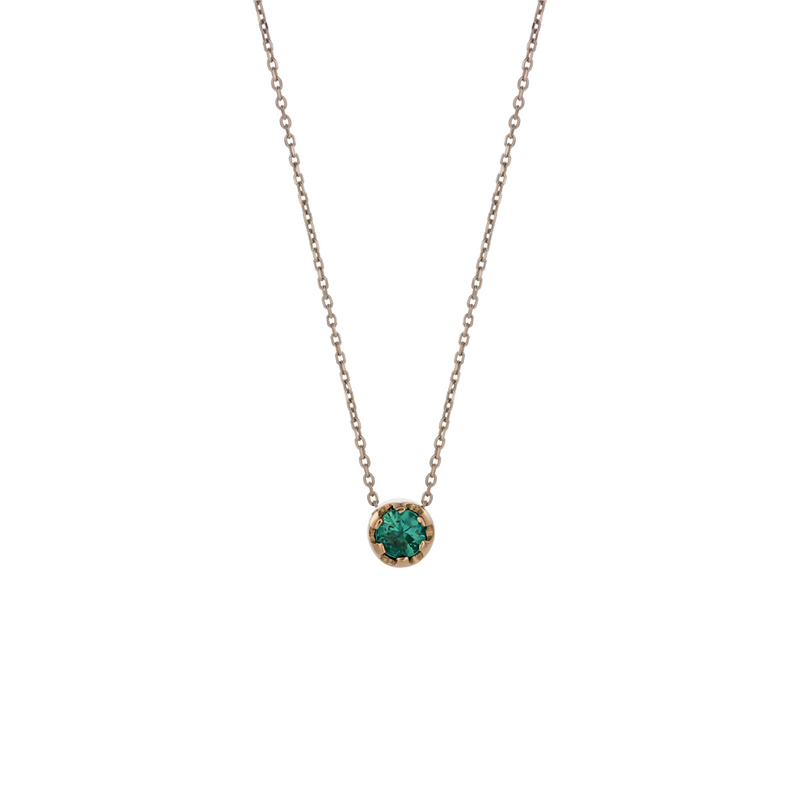 Yellow gold pendant featuring a round emerald, suspended from a delicate gold chain. 