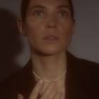 Woman wearing a delicate freshwater pearl necklace featuring organically shaped pearls and a minimalist yellow gold clasp.