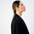Woman wearing minimalist stud earrings featuring pear-cut diamonds set in 14k yellow gold.