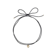 Black choker necklace with a gold charm on a white background