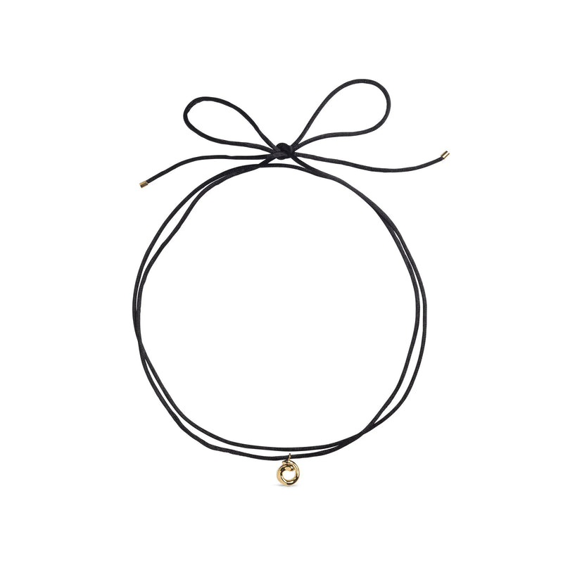 Black choker necklace with a gold charm on a white background