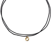 Black cord necklace with a gold pendant on a white background