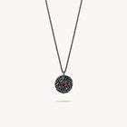 Oxidised silver chain necklace featuring a round, textured disc pendant with a small red sapphire set in the center
