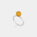 A sleek silver ring featuring a medium size natural Baltic amber stone.