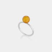 A sleek silver ring featuring a medium size natural Baltic amber stone.