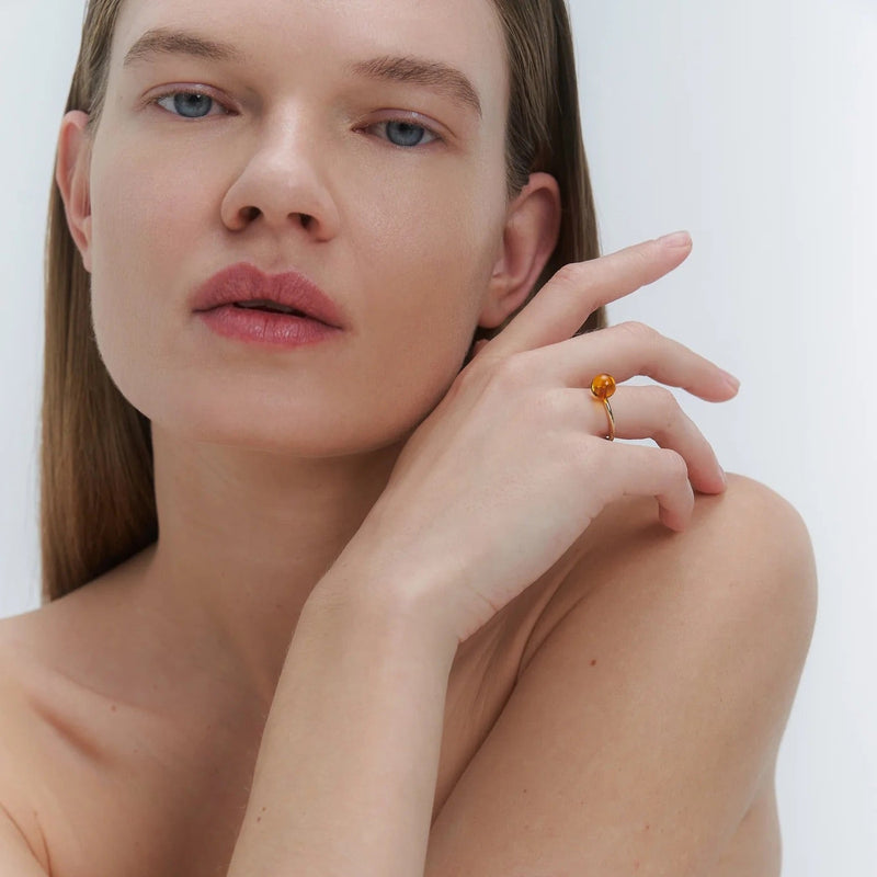 Woman with a ring on her finger against a white background