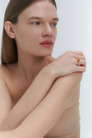 A sleek gold ring featuring a medium size natural Baltic amber stone.