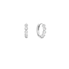 A pair of small silver huggie hoop earrings, shown from the side and back, each adorned with five clear round-cut topaz gemstones in a bezel setting, on a solid white background.
