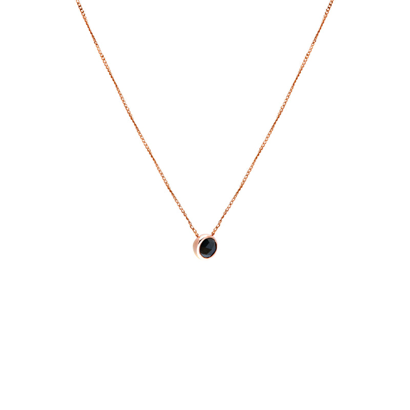 A delicate rose gold chain necklace with a small bezel-set ocean blue diamond pendant, shown against a plain white background.