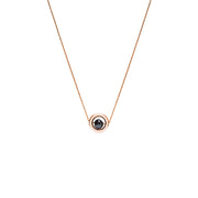 A delicate rose gold chain necklace featuring a small circular pendant with a gold outer ring and a dark, nearly black, faceted diamond, shown against a plain white background.