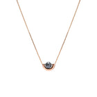 A delicate rose gold chain necklace featuring a small, polished gold crescent-shaped setting holding a round, dark gray diamond, presented on a solid white background.